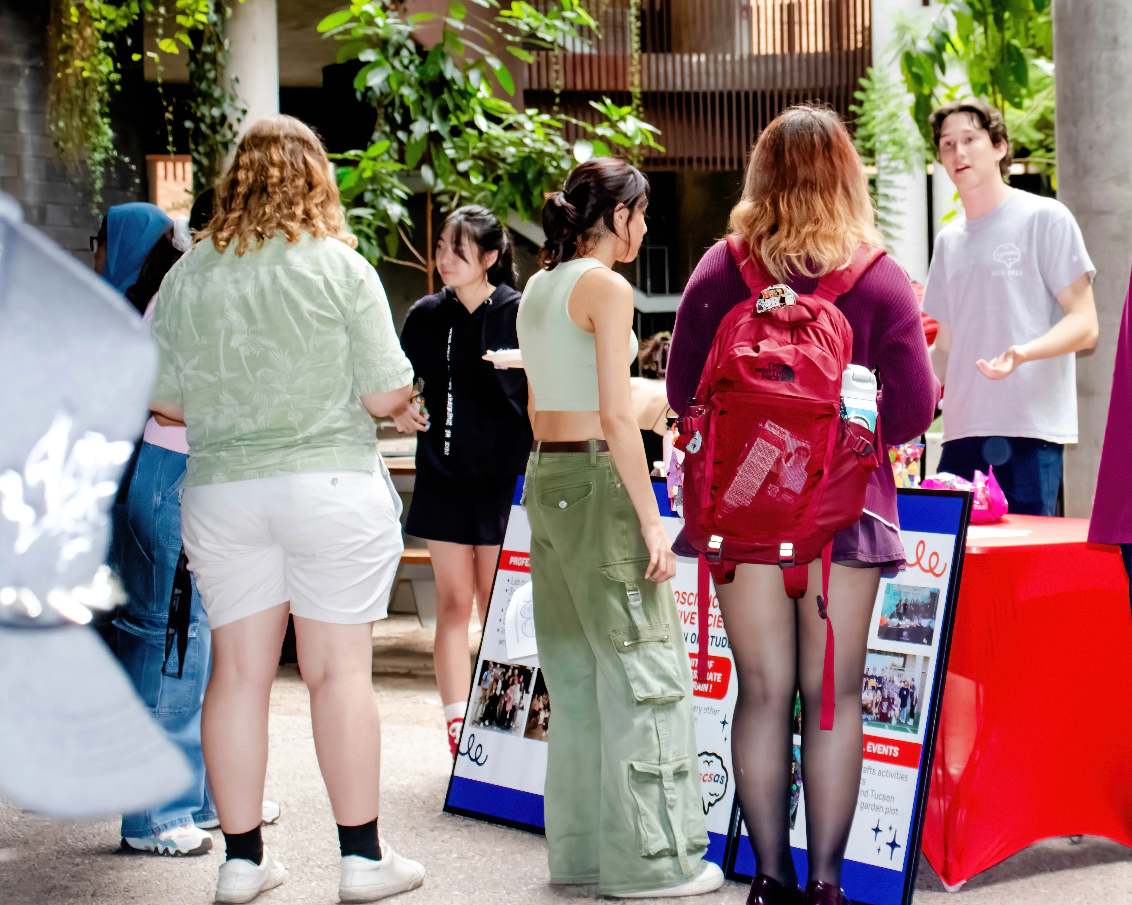 Welcome Event with students standing behind a table interacting with other students in the ENR2 courtyard