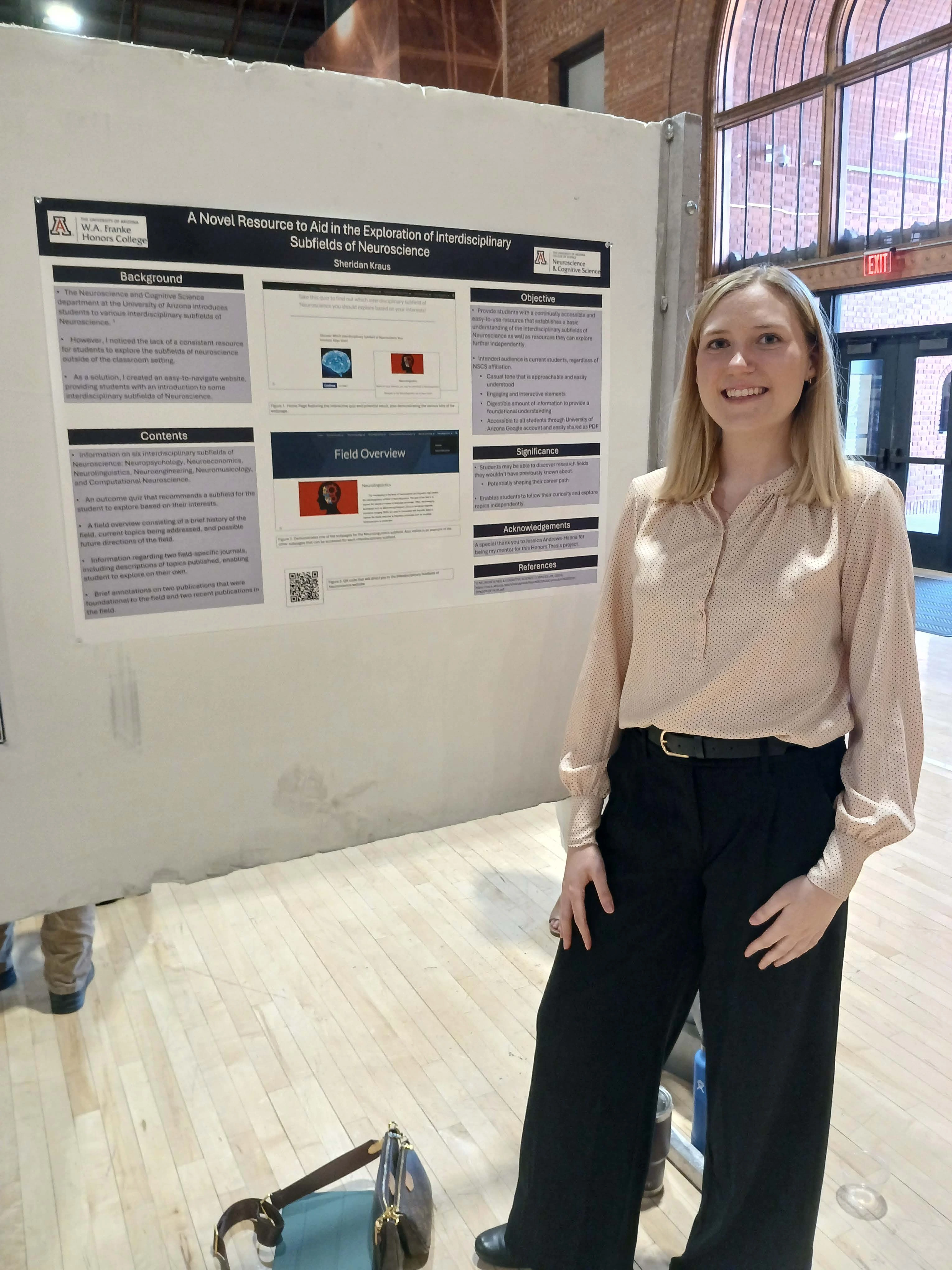 Undergraduate student standing next to their Capstone Project