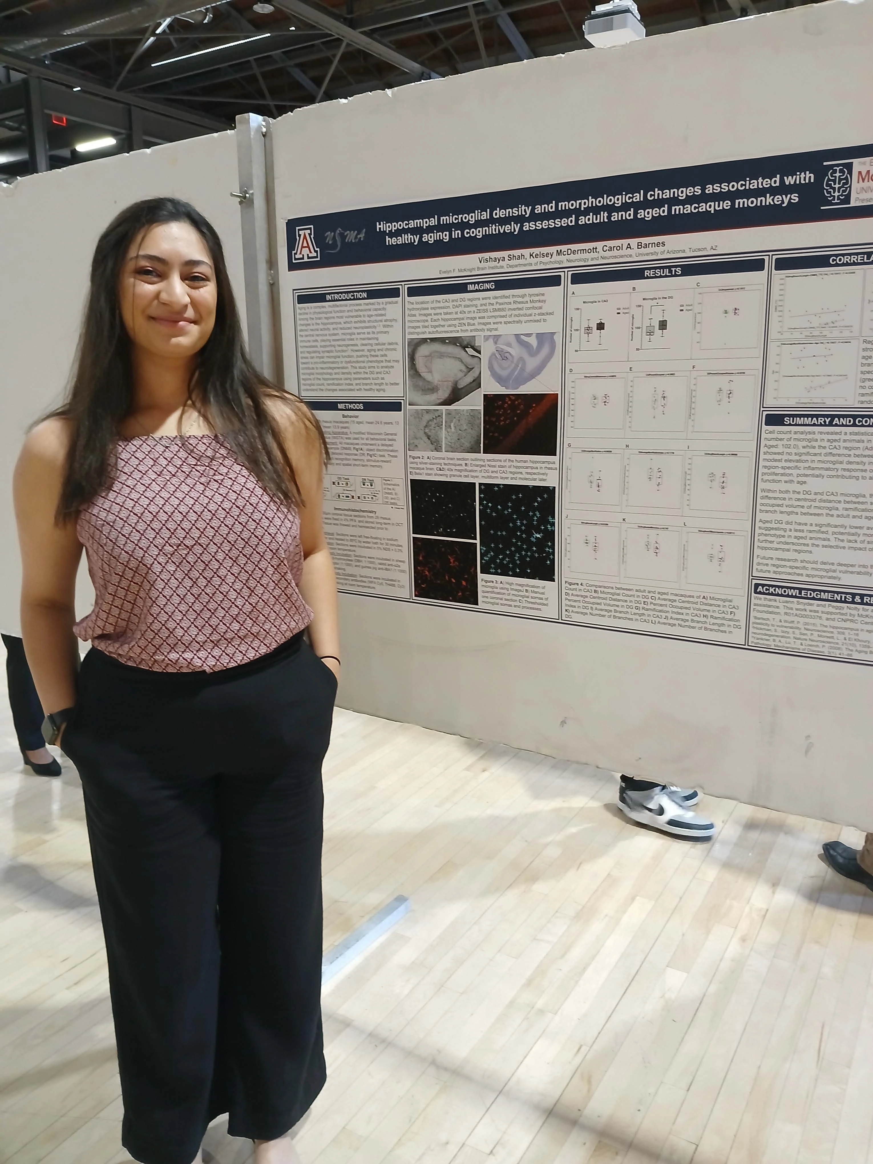 Undergraduate student standing next to their Capstone Project